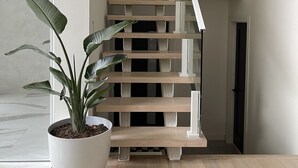 A staircase with a white railing and a potted plant on the landing. - Minimalist sauna retreat  (Brighton)