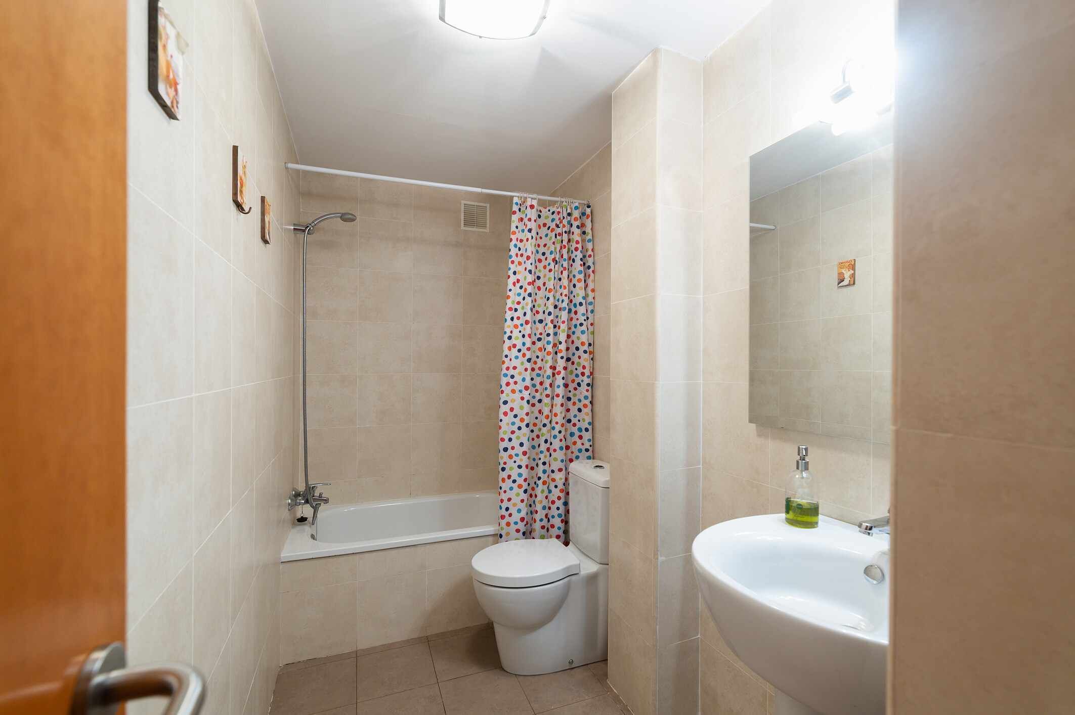Un baño con bañera, inodoro y lavamanos.