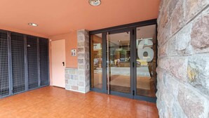 L’entrée d’un hôtel, avec un mur en pierre, une porte en verre portant le numéro « 6 » et un sol carrelé.