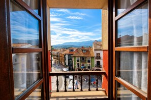 A balcony with a view of colorful buildings and mountains in the distance.