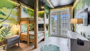 A room with a bunk bed, a desk, and a window with curtains.