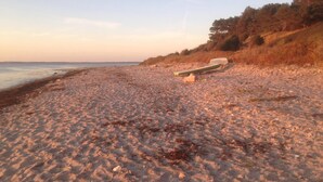 A beach with a boat and a cooler on the sand. - Cottage by Veddinge in charming 70s style (Fårevejle)