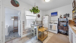 A modern kitchen with a wooden countertop, a hanging plant, and a built-in oven.