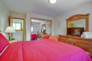 A hotel room with a large bed, a wooden dresser, a television, and a mirror. - The Big Lift-abowski 3BA/2BA. Close to Mountain and Skiing! (Killington)