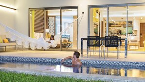 A pool area with a hammock, a dining area, and a view into the interior of the building. - 2 Bedroom Swim Up Suite Cancun (Cancun)
