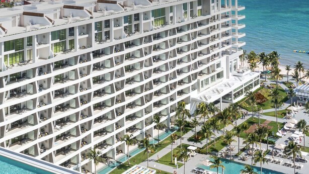 A high-rise hotel with multiple balconies, a pool area with lounge chairs, and a view of the ocean. - 2 Bedroom Swim Up Suite Cancun (Cancun)