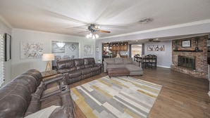 A spacious living room with a sectional sofa, a fireplace, and a dining area.