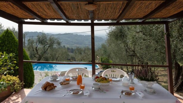 A table set for breakfast with a view of a pool and mountains. - Chantal by Interhome (Capannori)