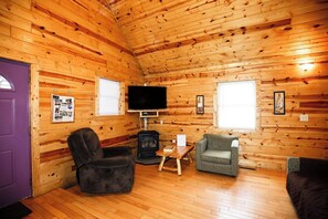 A log cabin interior with a fireplace, a television, and seating arrangements. - 2 Bedroom 2 Bath Cabin with Hot Tub (Beaver, WV) (Beaver)