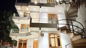 Une maison moderne à deux étages, dotée d’un balcon, d’un escalier et d’une pelouse bien entretenue.