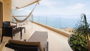 A balcony with a hammock, seating, and a view of the sea. - Junior Panoramic Suite Pureto Vallarta (Puerto Vallarta)