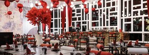 Un restaurant amb llanternes vermelles, una gran decoració d'arbre i una zona de bar.