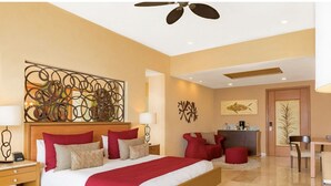 A modern hotel room with a large bed, a desk, and a seating area. - Junior Panoramic Suite Pureto Vallarta (Puerto Vallarta)