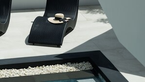 A pool area with two lounge chairs and a pebble-lined edge. - Attractive SeaView 4br Private PoolVilla (Rawai)
