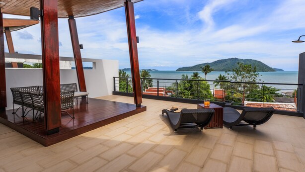 A balcony with wooden flooring, a covered seating area, and a view of the sea. - Attractive SeaView 4br Private PoolVilla (Rawai)