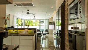 A modern kitchen with a central island, built-in oven, and ample counter space. - Attractive SeaView 4br Private PoolVilla (Rawai)
