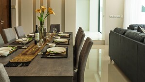 A modern dining area with a long table, chairs, and a ceiling fan. - Attractive SeaView 4br Private PoolVilla (Rawai)