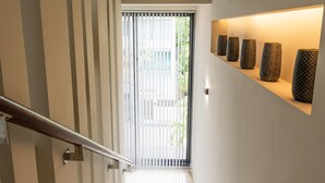 A modern staircase with a metal handrail, leading to a door with vertical blinds. - Attractive SeaView 4br Private PoolVilla (Rawai)