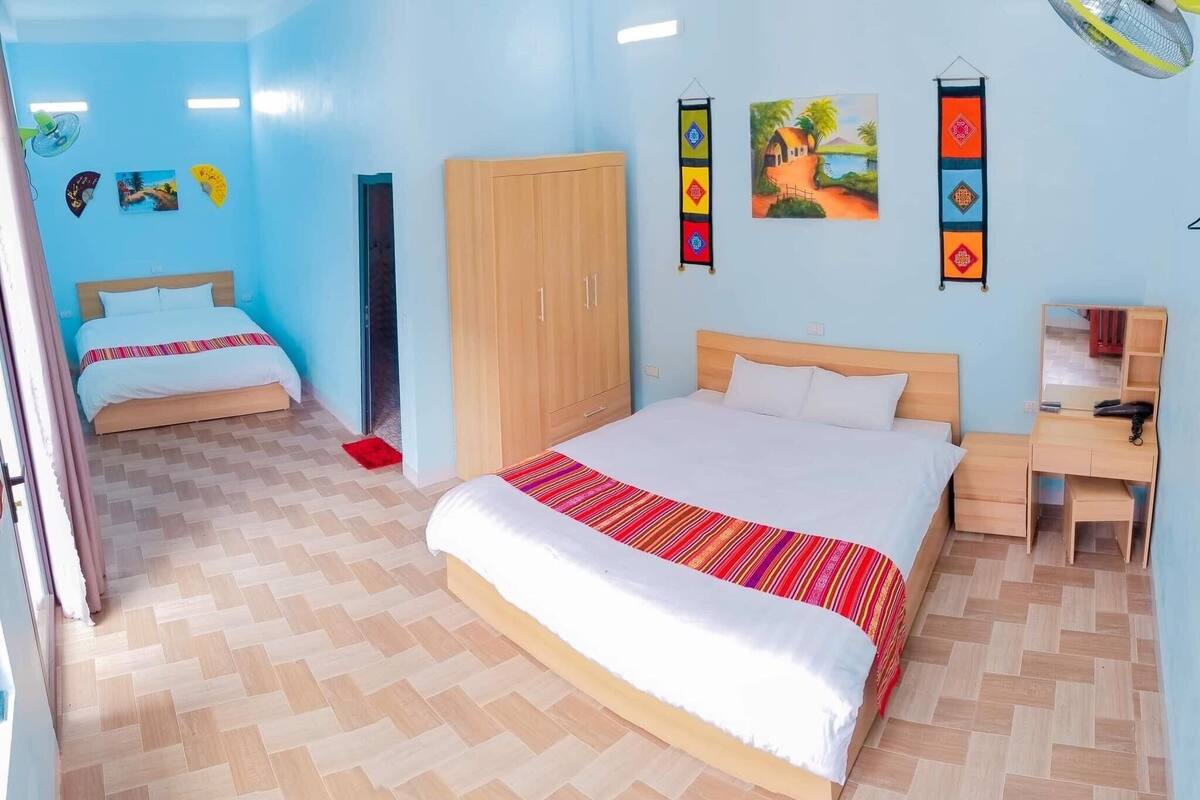 Une chambre avec deux lits, une armoire, un bureau et un miroir.