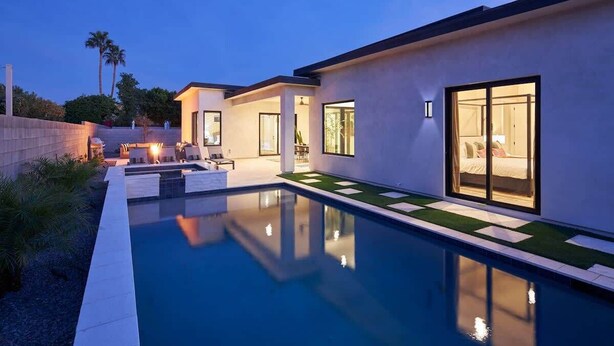 A modern house with a swimming pool, large windows, and a well-lit patio area. - Luna Luxe - Pool Heat Avail- Hot Tub - Fire Pit! (Scottsdale)