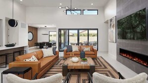 A spacious living area with a fireplace, a dining table, and a large window overlooking a garden. - Luna Luxe - Pool Heat Avail- Hot Tub - Fire Pit! (Scottsdale)