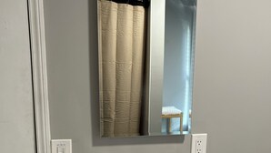 A bathroom with a white sink, a mirror, a towel rack, and a shower curtain. - Cozy 1-bedroom apartment with king size bed. (Towson)