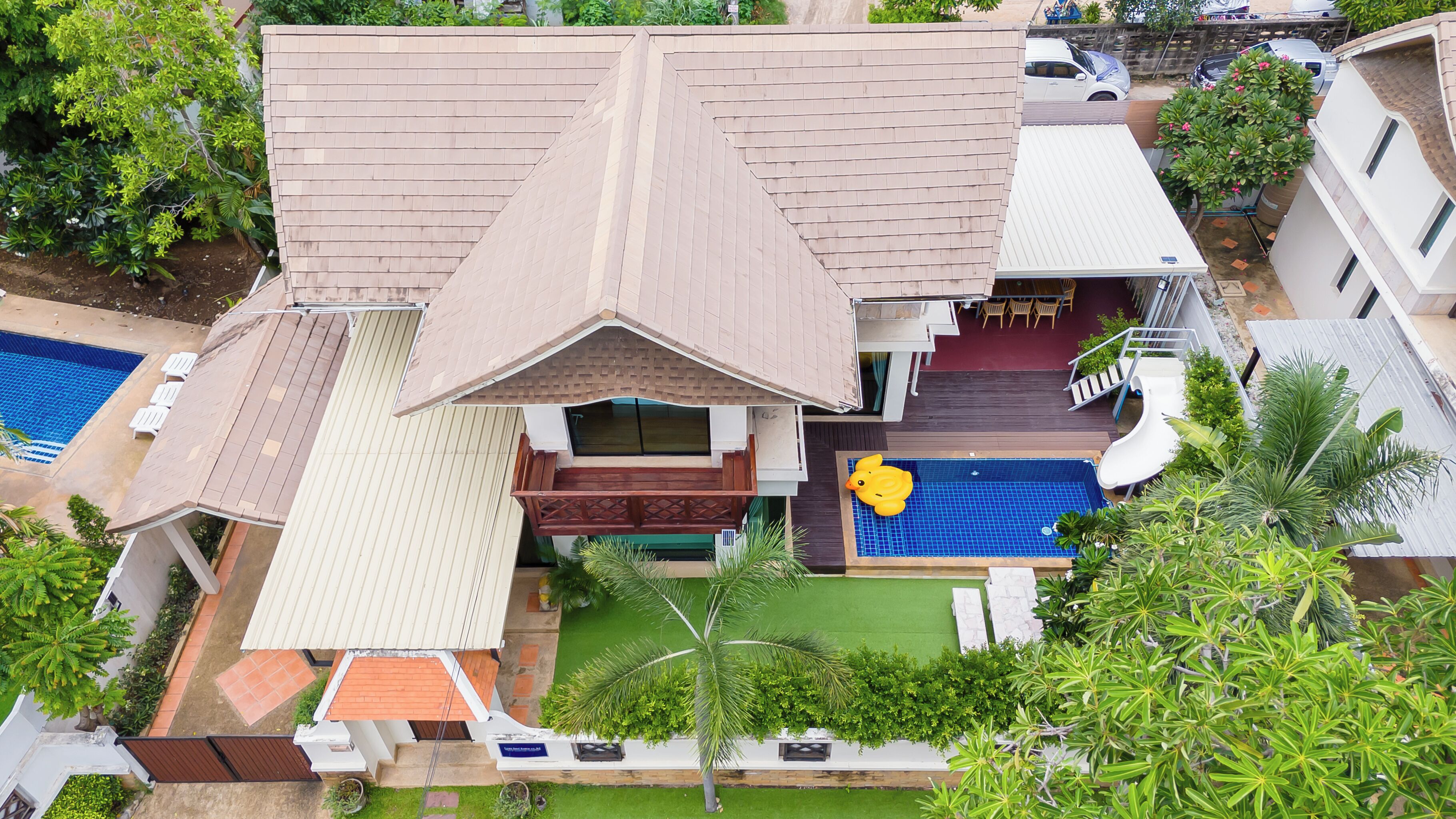 Una proprietà residenziale con piscina, patio coperto e giardino curato.