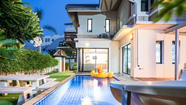 A modern house with a swimming pool, outdoor seating, and a slide. - Natcha Pool Villa by Warin (Pattaya)