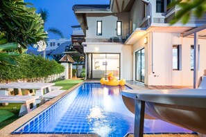 A modern house with a swimming pool, outdoor seating, and a slide. - Natcha Pool Villa by Warin (Pattaya)