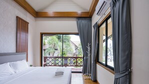 A hotel room with a bed, a balcony, and a view of the outside. - Natcha Pool Villa by Warin (Pattaya)