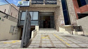 Un immeuble sur lequel on peut voir plusieurs enseignes indiquant « Vans Premium », « Loja Tours » et « Suitesecu Rentals ».