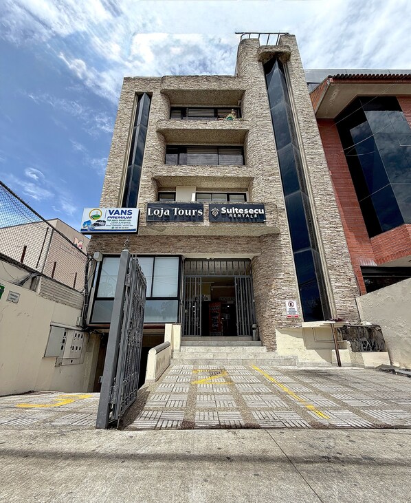 A building with multiple signs for 'Vans Premium', 'Loja Tours', and 'Suitesecu Rentals'.