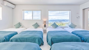 A hotel room with four beds, two windows, and a view of the landscape. - Nanki shirahama View point (Shirahama)