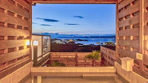 A wooden balcony with a view of a coastal town at dusk. - Nanki shirahama View point (Shirahama)