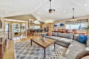 A spacious living room with a large sofa, a wooden coffee table, and a patterned rug. - Ski Basecamp, Forest Land, Hot Tub & Pool Table (South Lake Tahoe)