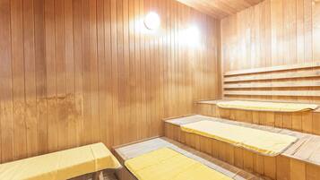 A sauna room with wooden walls and benches.