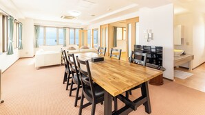 A spacious conference room with a long wooden table, black chairs, and a white sofa. - Livemax Resort Shiretoko Seafront (Rausu)