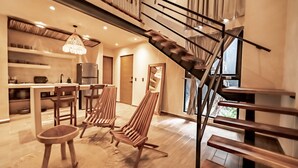 A modern interior with a wooden staircase, a dining area, and a kitchen. - The Teodoro (Tulum)
