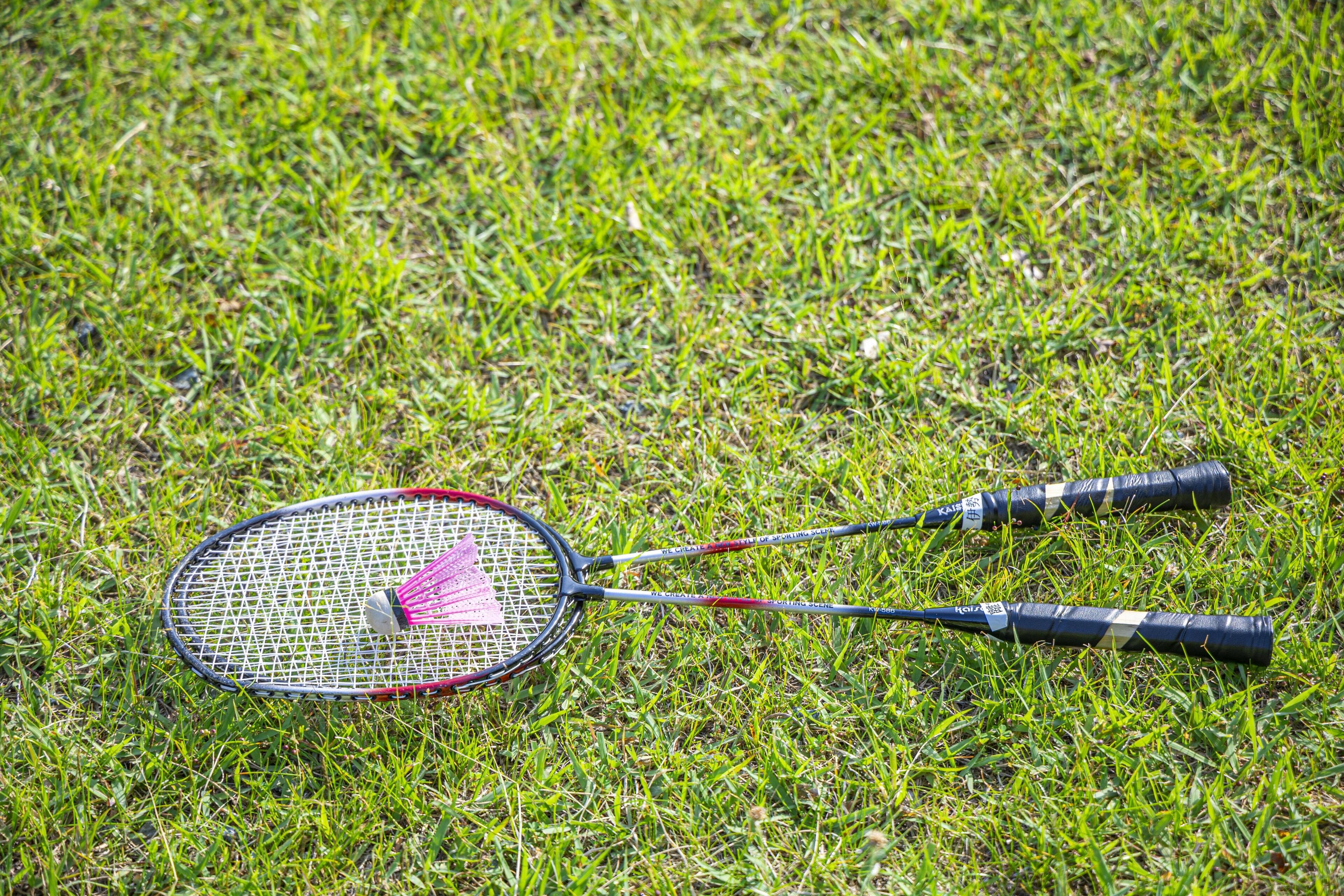 A badminton racket lying on grass.