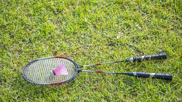 A badminton racket lying on grass.