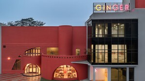 A modern building with a prominent 'GINGER' sign, featuring a unique architectural design with curved walls and large windows.