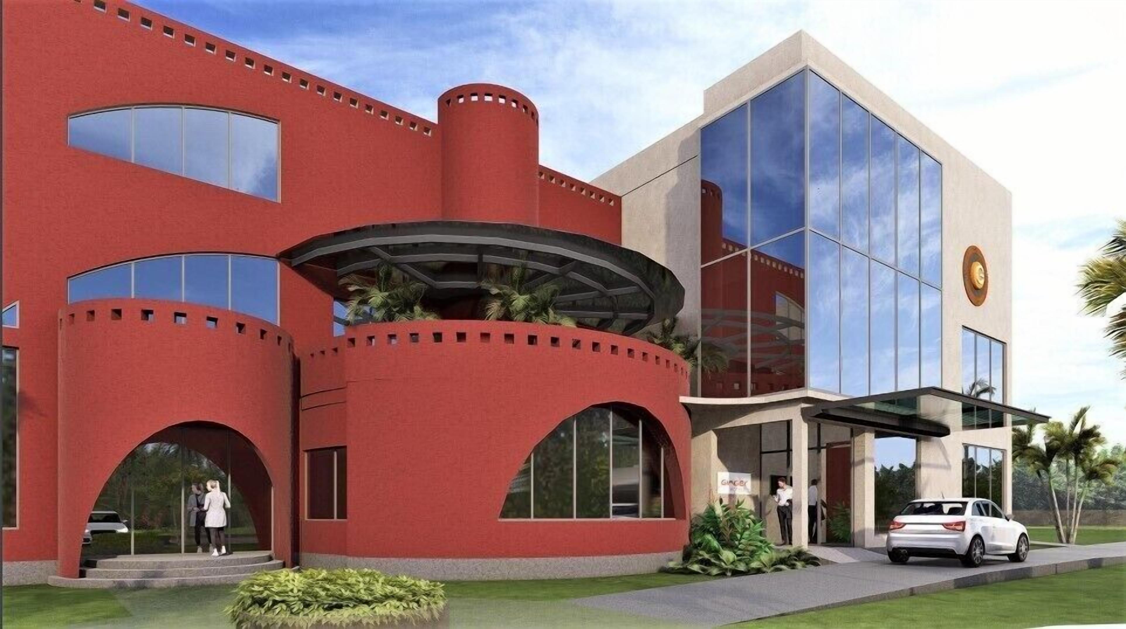 Un bâtiment moderne avec une façade rouge, de grandes fenêtres et une entrée en verre.