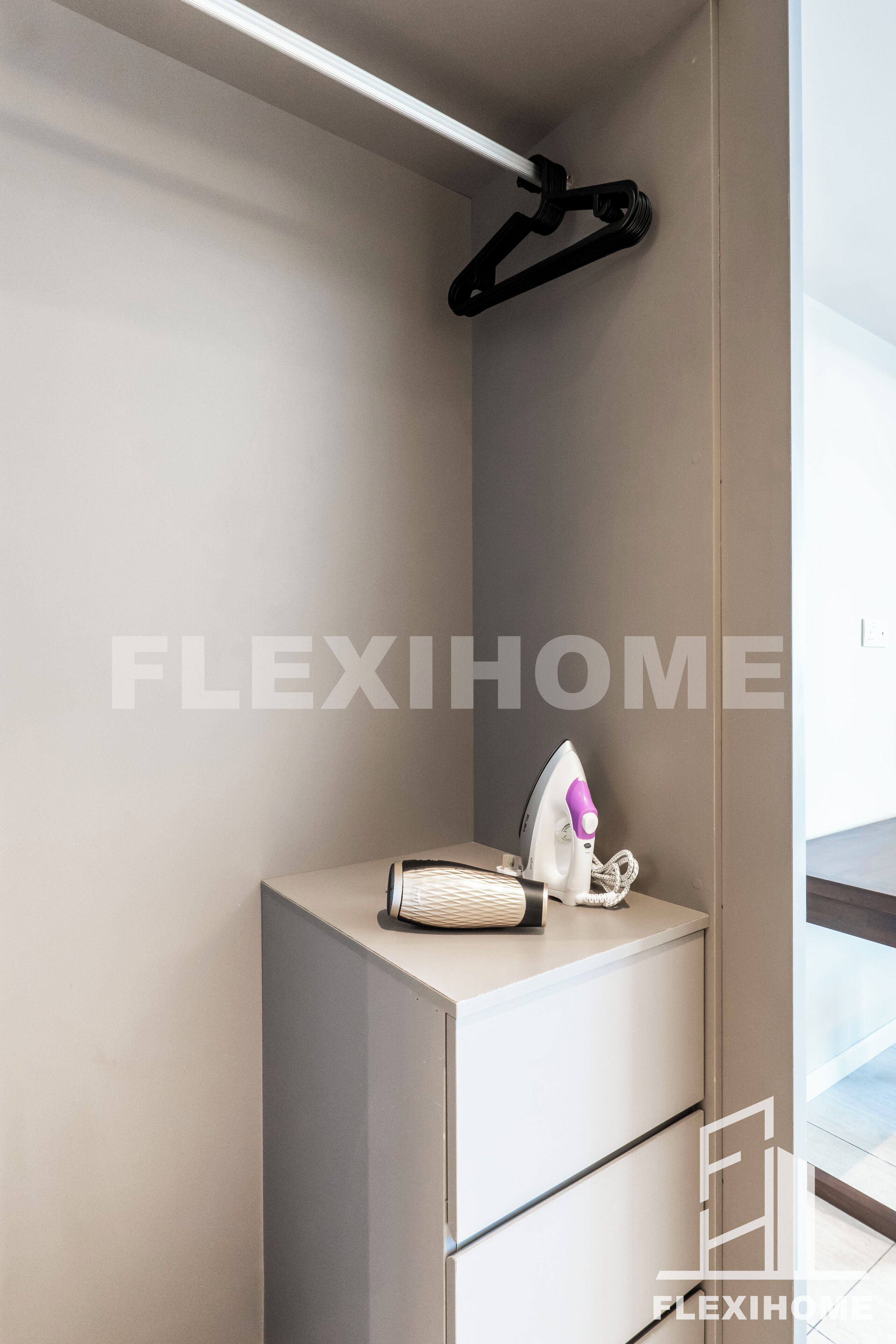 A modern bathroom with a minimalist design, featuring a built-in vanity with a mirror and a hanging towel rack.