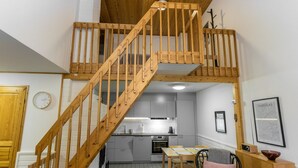 Un appartement de style « loft » avec un escalier en bois reliant les deux étages.