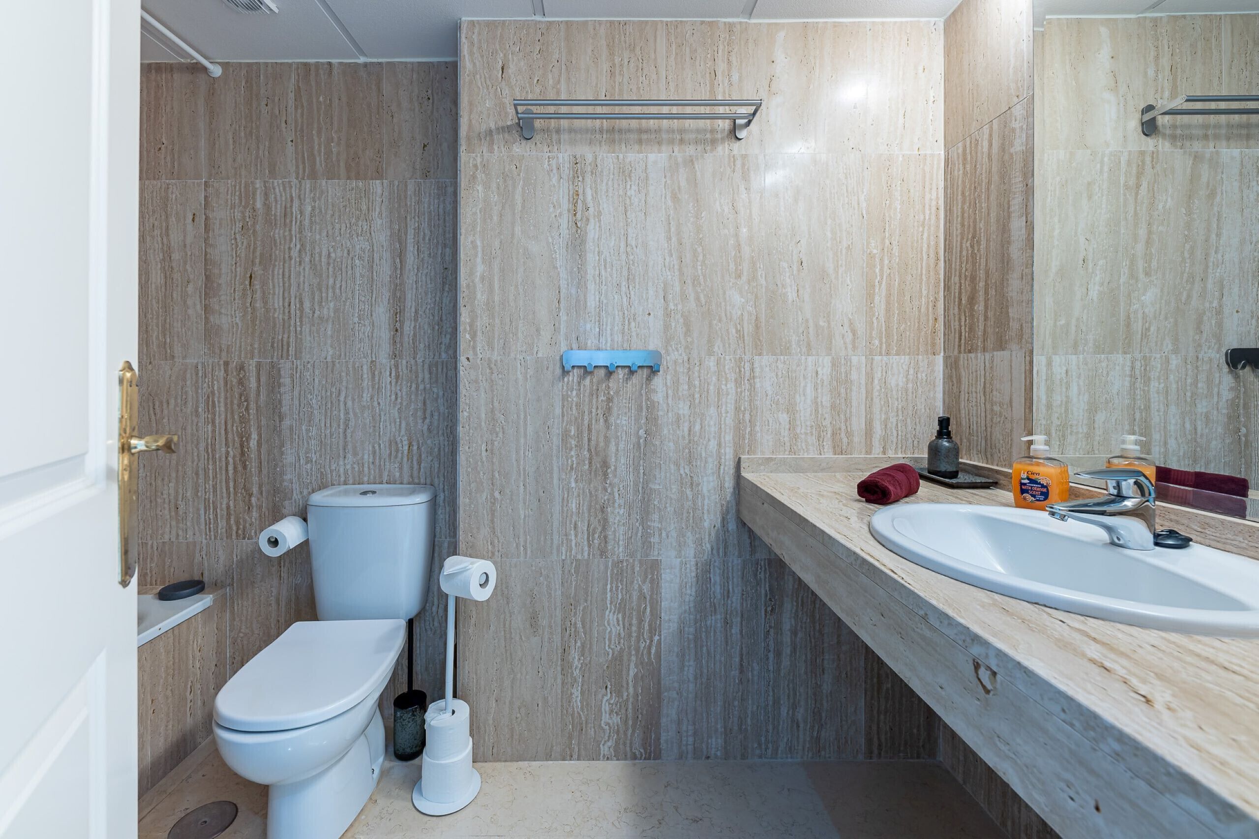 A bathroom with a toilet, sink, and mirror.