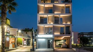 A multi-story hotel with balconies, a McDonald's restaurant, and a Wi-Fi sign. - Athinais Apartments (Heraklion)