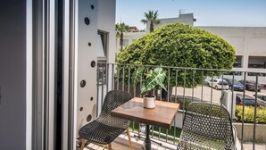 A balcony with two chairs, a small table, and a potted plant. - Athinais Apartments (Heraklion)