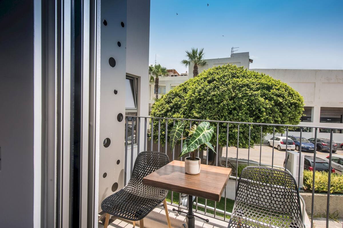 Ein Balkon mit zwei Stühlen, einem kleinen Tisch und einem Blumentopf.