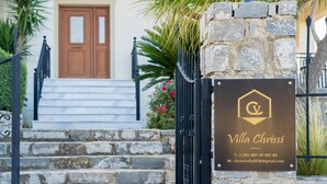 A stone staircase leading to a villa entrance with a plaque displaying the name 'Villa Chrissi' and contact information. - Villa Chrissi Kissamos (Kissamos)