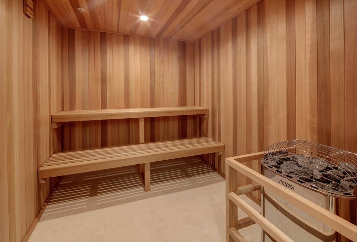 A wooden sauna with benches and a sauna heater.